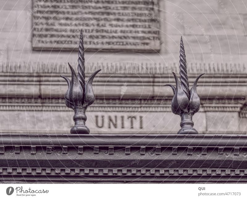 UNITI Schriftzug hinter schmiedeeisernen Zaunspitzen Schmiedekunst Schmiedeeisen Tor alt Eisen Metall Handwerk historisch Einigkeit silbern Architektur Wand