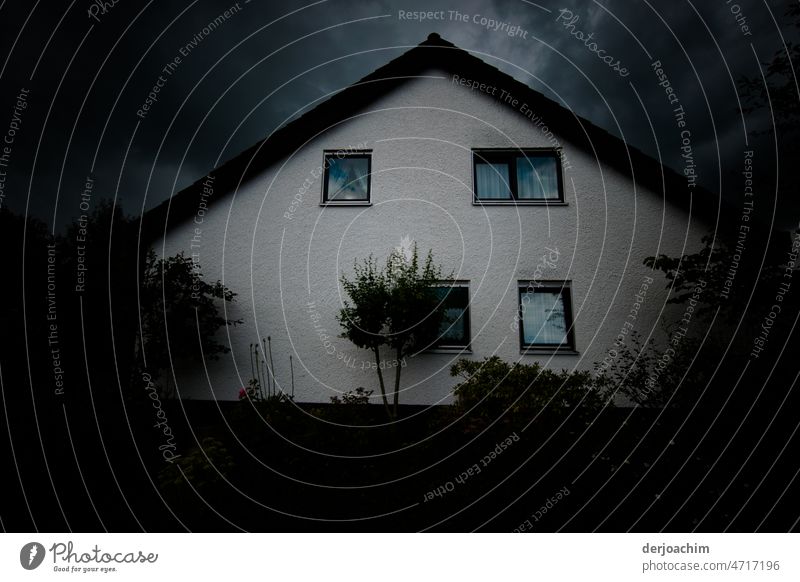 Ein kleines Einfamilienhaus in Franken.  Über dem Haus braut sich ein Unwetter am Himmel auf. Der Tag wird zur Nacht. Gebäude Architektur Fassade Fenster