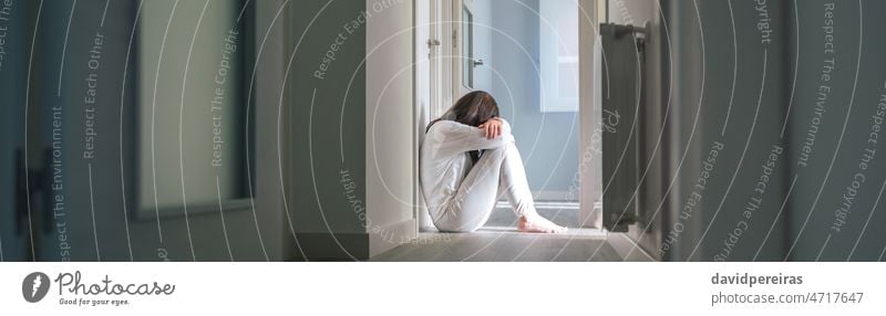 Frau im Schlafanzug sitzt auf dem Boden eines psychiatrischen Zentrums unkenntlich Pyjama mental Erkrankung Zentrum für psychische Gesundheit Probleme Sitzen