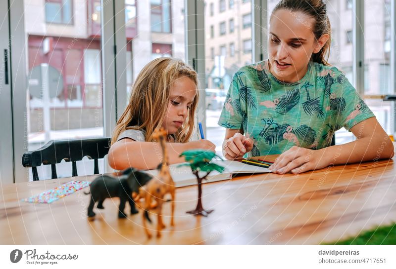 Mutter und Tochter zeichnen zusammen Zeichnung schreibend Bildung zu erklären. Versöhnung Familienarbeit Lehre Kind Mädchen Menschen Frau Farbstift Kaukasier