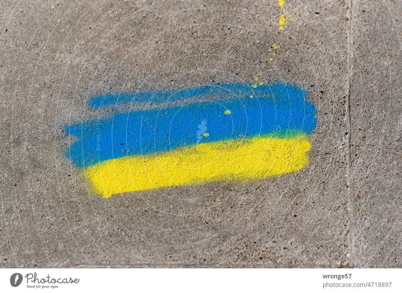 Blau-gelbe Farben als Zeichen der Solidarität mit der Ukraine auf grauen Beton gesprüht blau-gelb Krieg Frieden Politik & Staat Hoffnung Grauer Untergrund
