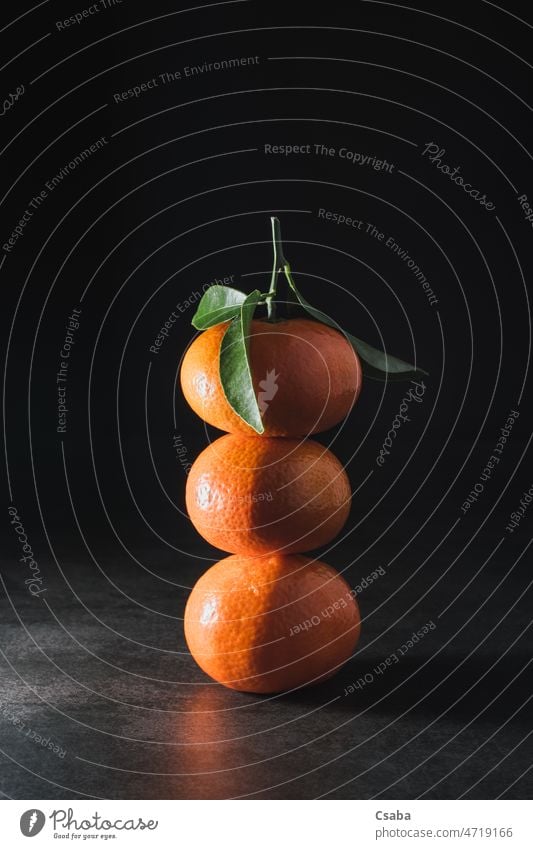 Frische Mandarine mit Blättern auf dunklem Hintergrund Clementine orange Zitrusfrüchte Frucht drei Textfreiraum clementina Zitrusfrucht reticulata