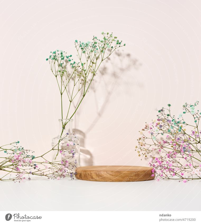 Bühne für die Präsentation von Produkten, Kosmetika mit einem runden Holzpodest und einer Glasvase mit einem Blumenstrauß geblümt Werbung Hintergrund Schönheit