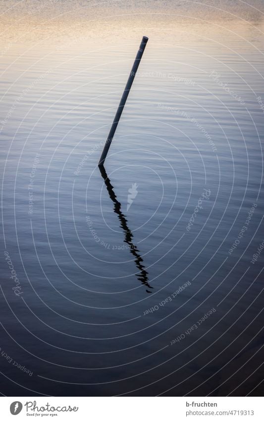 Eisenstange steckt in einem Gewässer Stange Stock See Wasser stehen einsamkeit ruhig Ruhe Einsamkeit Reflexion & Spiegelung Menschenleer Wasseroberfläche