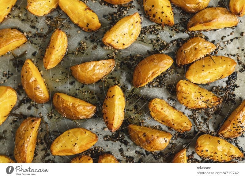 Gebackene Kartoffelspalten auf einem Backblech Keil Mahlzeit gebraten selbstgemacht gekocht Würzig Top Backpapier Ansicht Hintergrund Ofen Chips Nahaufnahme