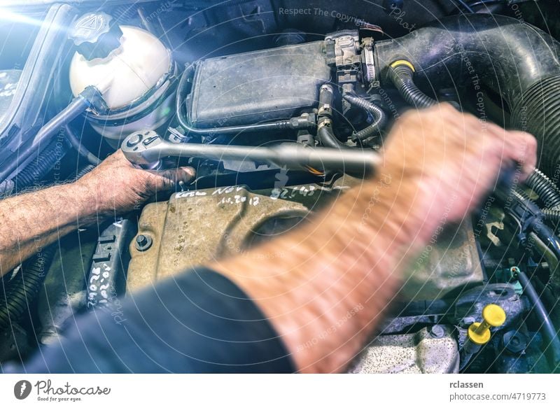 Automechaniker bei der Arbeit an einem Automotor in einer Autowerkstatt. Reparaturservice. Authentische Nahaufnahme mit Bewegungsunschärfe PKW Mechaniker Dienst