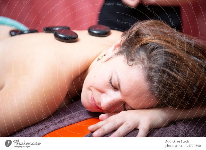 Frau bei der Massage mit heißen Steinen Masseur Frauen Rücken Spa Salon Klient Therapie Leckerbissen Körperpflege Verfahren sich[Akk] entspannen professionell