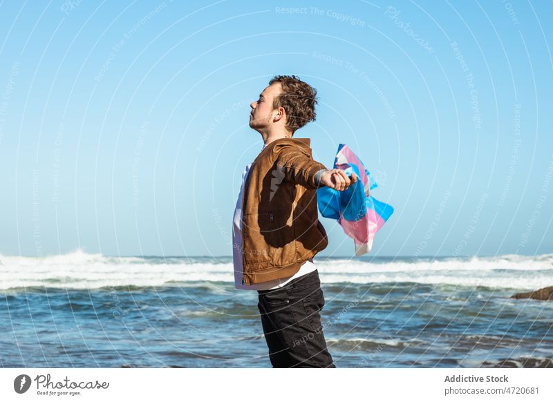 Mann mit bunter Transgender-Flagge am Meer Fahne lgbtq Identität Freiheit gleich MEER Küste Natur Meeresufer Ufer männlich Strand Wasser winken Seeküste