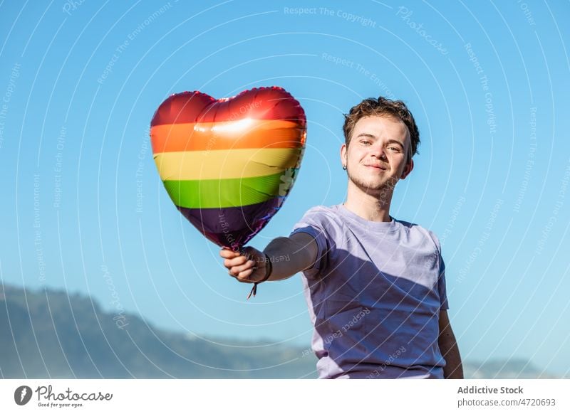 Fröhlicher Mann mit LGBT-Luftballon Transgender lgbt lgbtq Herz Identität Freiheit gleich schwul Homosexualität Stolz Toleranz Symbol heiter Geschlecht