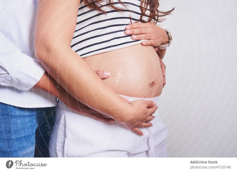 Anonymer Ehemann berührt den Bauch einer schwangeren Frau Paar Bauch anfassen Schwangerschaft warten erwarten Kinderkriegen pränatal Liebe Streicheln mütterlich