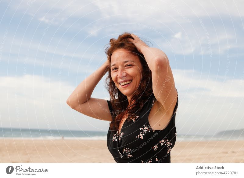 Frau mit den Händen auf dem Kopf schaut in die Kamera Vorschein feminin Stil Natur Harmonie friedlich verträumt Haare berühren Sommer Himmel wolkig Sonnenkleid