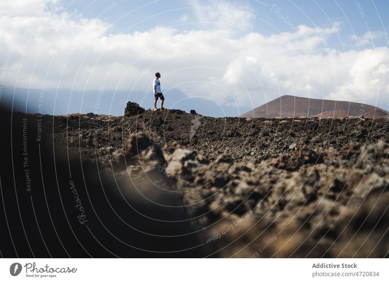 Mann steht während eines Ausflugs in einem vulkanischen Tal Tourist Urlaub Tourismus Fotoapparat Abenteuer wüst erkunden männlich ernst Natur stehen