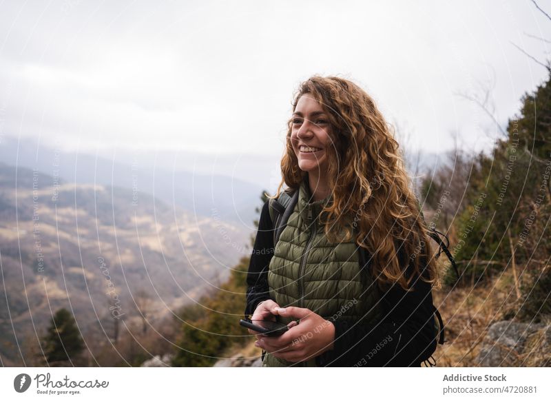 Fröhliche Frau mit Smartphone auf einem Berg Reisender Wanderer Berge u. Gebirge Hochland Trekking Natur Abenteuer Wanderung erkunden Aktivität Ausflug Fernweh