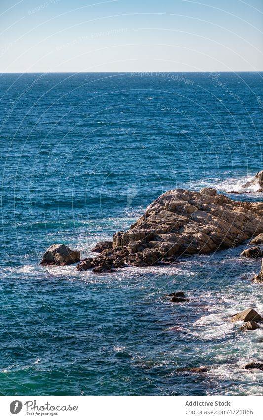 Schaumige Meereswellen plätschern im Sonnenlicht an das felsige Ufer MEER winken Klippe Meereslandschaft Meeresufer Natur malerisch Küstenlinie platschen Kraft