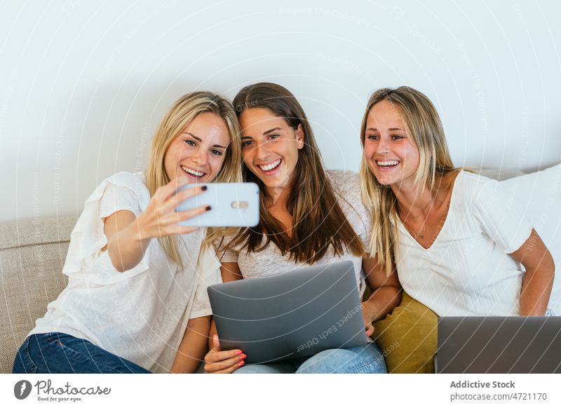 Frau macht ein Selfie mit ihren Schwestern Frauen Freundschaft Smartphone Zeitvertreib online Wohnzimmer Liege Internet heimwärts Bonden Zeit verbringen froh