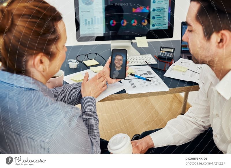 Geschäftskollegen, die per Videoanruf Finanzdaten besprechen und zusammen im Büro arbeiten. Unternehmer arbeiten mit Diagrammen und Tabellen am Computer. Team arbeitet zusammen