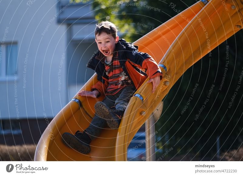Spass auf dem Spielplatz Rutsche Rutschbahn Freude überschwänglich Kindheit Junge Geschwindigkeit Spielen Außenaufnahme Spaß Freizeit & Hobby Fröhlichkeit