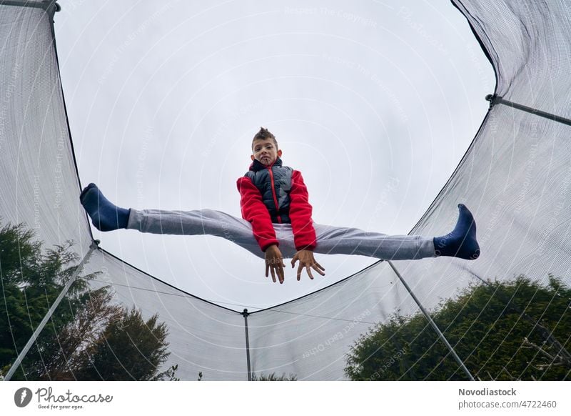 Porträt eines 9-jährigen Jungen, der auf einem Trampolin springt springen hoch jung Spaß Kaukasier aktiv Lifestyle vereinzelt Glück Beine im Freien Körper