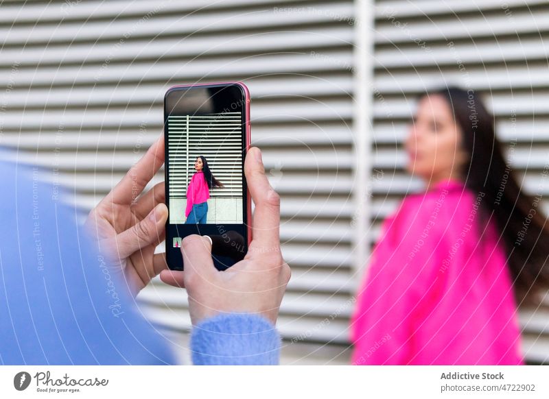 Gesichtslose Person, die eine hispanische Frau fotografiert fotografieren Fotograf Smartphone Straße einfangen Wand Fotografie Stil feminin Bildschirm Moment