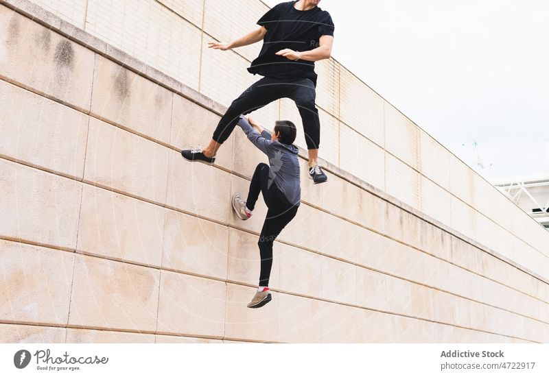 Energiegeladene Athleten, die sich von der Wand abstoßen Mann springen Sport Training Gebäude aktiv schieben männlich Männer Typ Trick anonym unkenntlich
