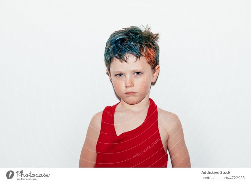 Beleidigter Junge mit gefärbtem Haar Kind unanständig schelmisch rebellisch Porträt ungehorsam widerspenstig beleidigt nachtragend ernst Raum Licht farbenfroh