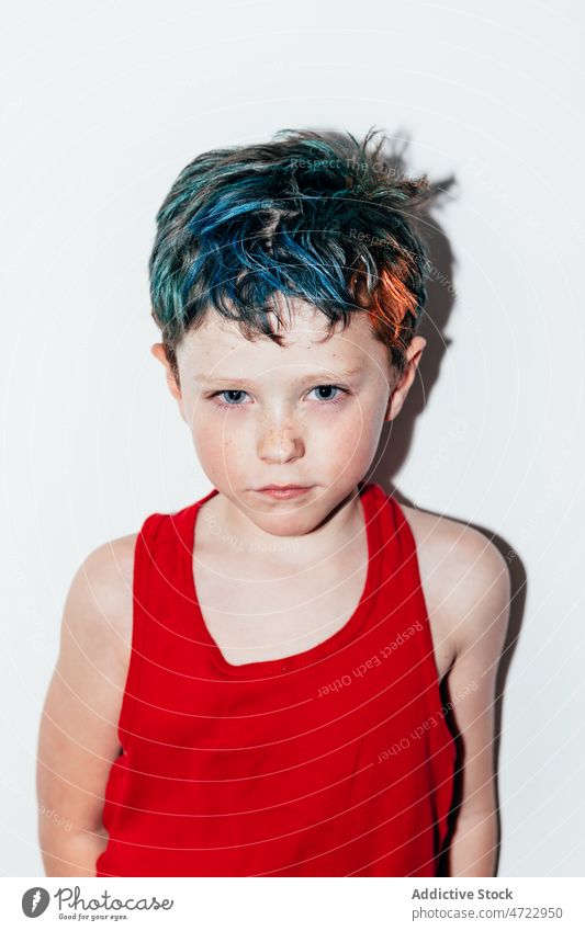 Beleidigter Junge mit gefärbtem Haar Kind unanständig schelmisch rebellisch Porträt ungehorsam widerspenstig beleidigt nachtragend ernst Raum Licht farbenfroh
