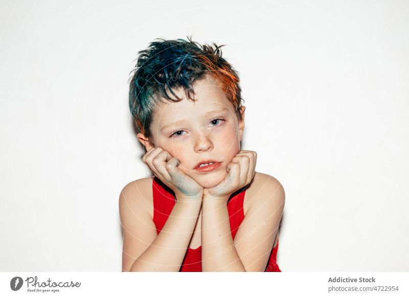 Gelangweilter Junge mit gefärbtem Haar schaut in die Kamera Kind traurig gelangweilt unanständig schelmisch rebellisch Porträt ungehorsam widerspenstig ernst