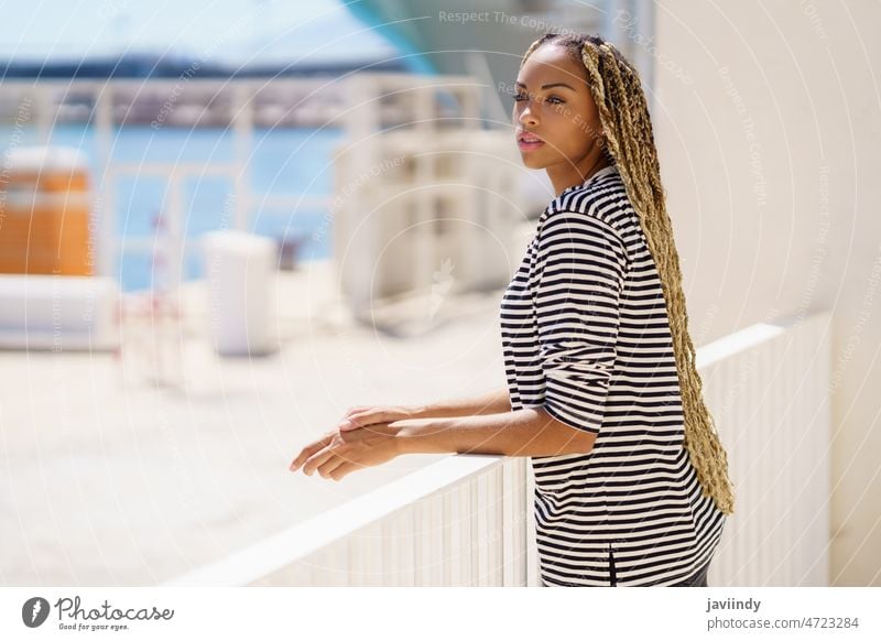 Junge schwarze Frau, die die Aussicht auf den Hafen genießt. Mädchen Lifestyle Glück Küste Lächeln Tourismus Feiertag reisen Sommer schön heiter jung attraktiv