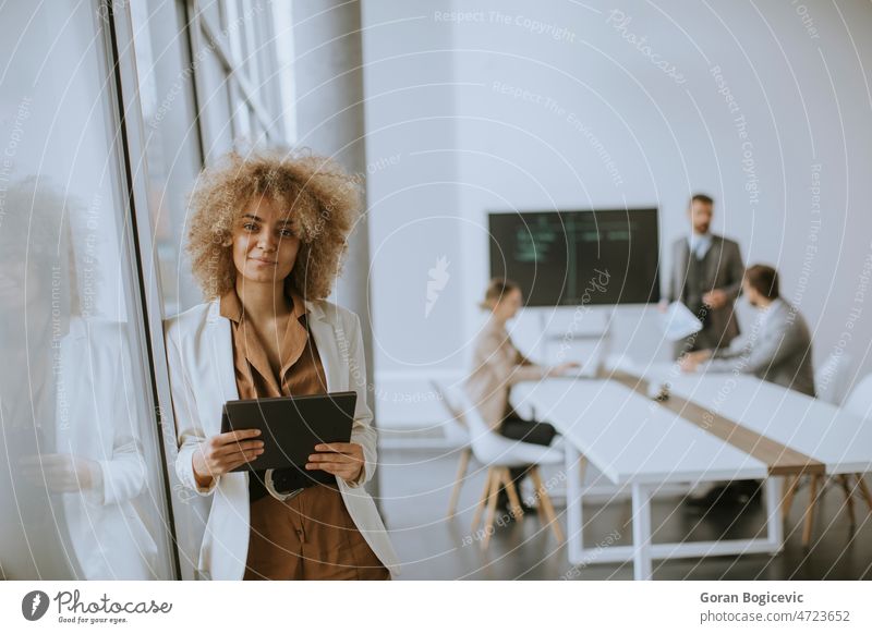 Junge Geschäftsfrau mit digitalem Tablet im Büro, hinter ihr arbeiten junge Leute Buchhaltung Business Geschäftsmann lässig Kaukasier Mitteilung Gespräch