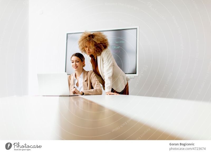 Junge Geschäftsfrauen diskutieren und benutzen einen Laptop in einem modernen Büro Buchhaltung Brainstorming Business Geschäftsmann Geschäftsleute lässig