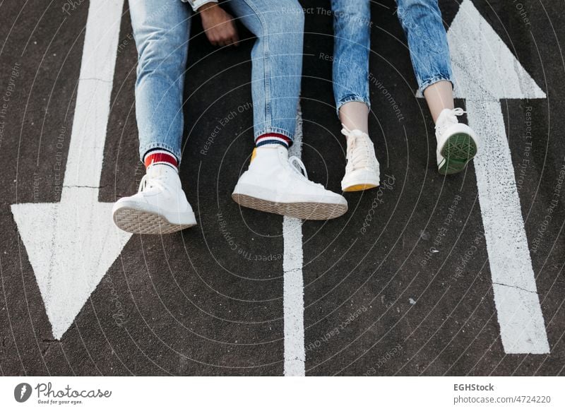 Unbekanntes junges Paar sitzt zwischen den Schildern auf dem Boden eines Skateparks Sitzen unerkannt unkenntlich Stock Skateplatz Freund Freundin Asphalt