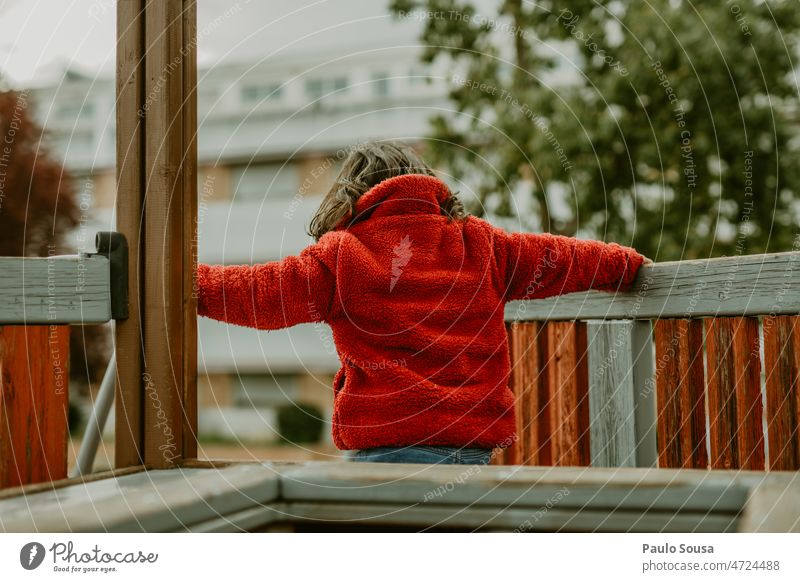 Rückansicht Mädchen mit roter Jacke auf Spielplatz Kind Kindheit Kindheitserinnerung Farbfoto Tag Außenaufnahme Mensch mehrfarbig niedlich Freude