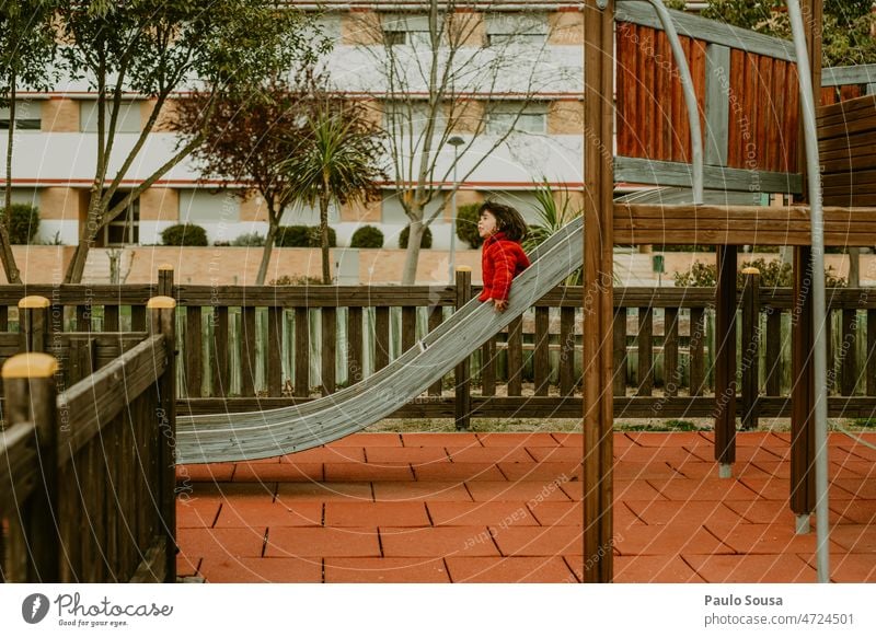 Mädchen mit roter Jacke spielt auf der Rutsche Spielplatz Spielplatzgeräte Sliden Spaß haben Spielen Freude Kindheit Freizeit & Hobby Kindergarten Außenaufnahme