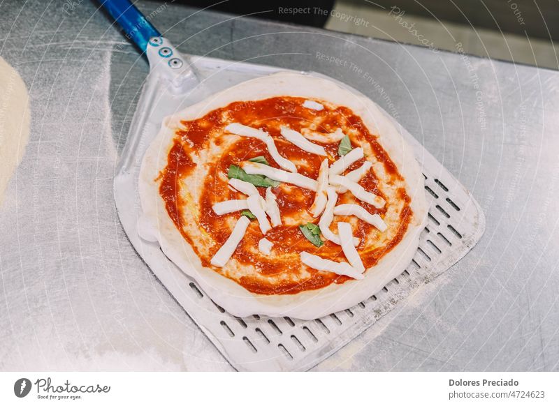 Zubereitung einer hausgemachten Pizza nach italienischer Art durch einen Fachmann backen Bäcker Bäckerei Käse Küchenchef Koch Kochen Essen zubereiten