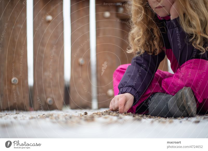 Mädchen auf dem Spielplatz im Winter ist traurig langeweile langweilig mädchen winter corona spielen spielplatz locken mähne weiblich schneeanzug spielen allein