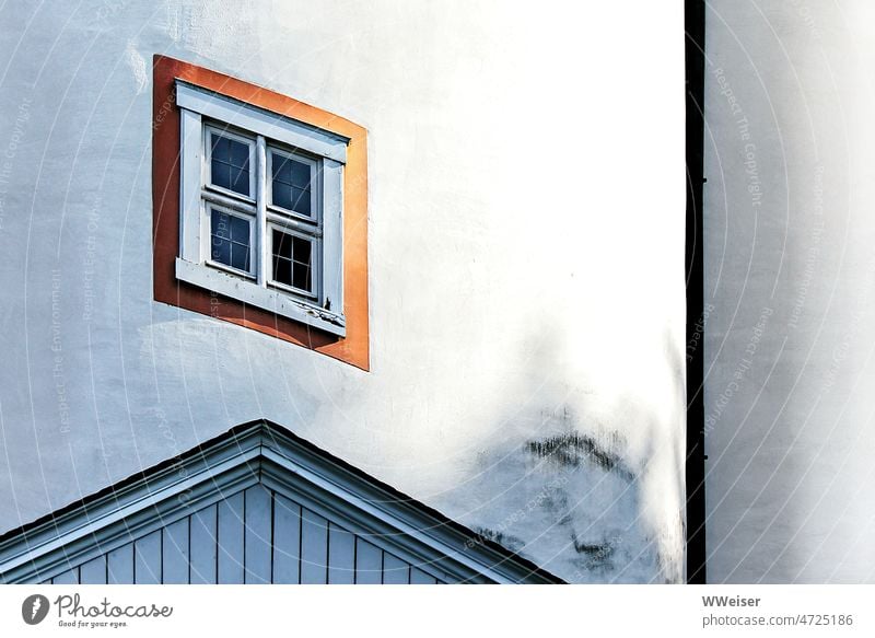 Ein schräges kleines Fenster in einer vor langer Zeit weiß verputzten gerundeten Fassade diagonal schief spitz Winkel Ecke eckig tünchen FassadeWand Schloss