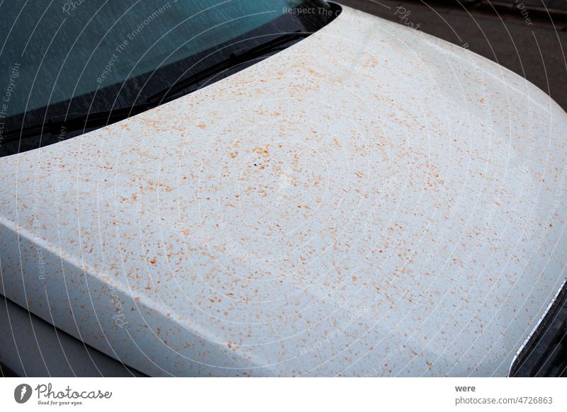 Motorhaube eines weißen Autos mit roten Staubflecken nach Blutregen Fender Naturphänomene Saharastaub Sahara-Wind Sand PKW Kapuze Regen Sandsturm Flecken