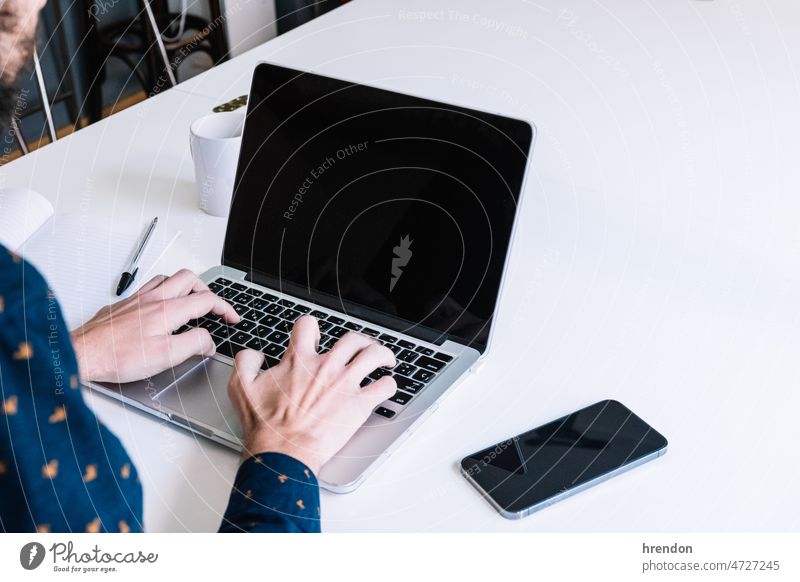 Nahaufnahme eines Mannes, der einen Laptop benutzt Heimarbeitsplatz arbeiten junger Erwachsener Arbeiter Lebensstile Kleinunternehmen Geschäftsmann Schreibtisch