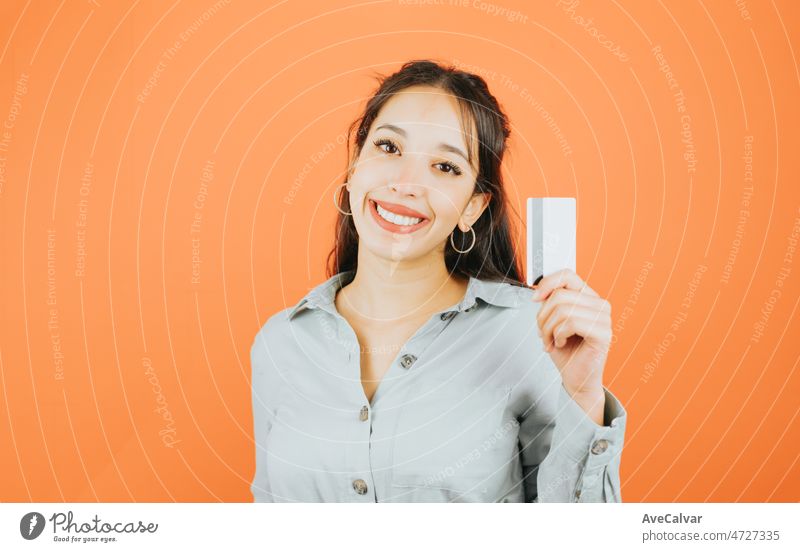 Junge Frau hält eine Attrappe Kreditkarte zeigt es in die Kamera, während lächelnd, Business und Freiberufler Konzept. Blauer Ton Farbe Hintergrund, Ausdruck der normalen Menschen. Mockup-Konzept mit Menschen