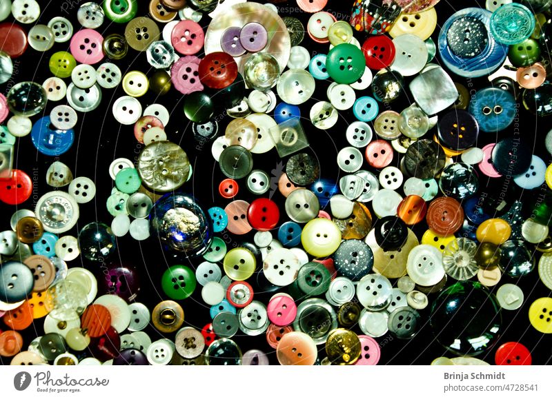 viele bunte Knöpfe flach auf einem Tisch, many colorful buttons flat lay on a table internet collage fashion object needlework accessory various clothes element
