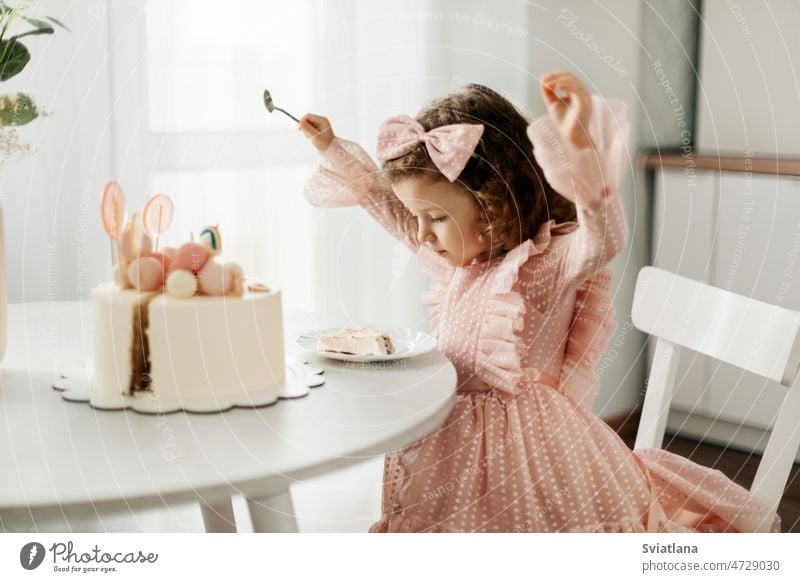 Niedliches kleines Mädchen isst an ihrem Geburtstag einen Geburtstagskuchen mit einem Löffel Kuchen Kind wenig hübsch essen heimwärts Glück Spaß süß