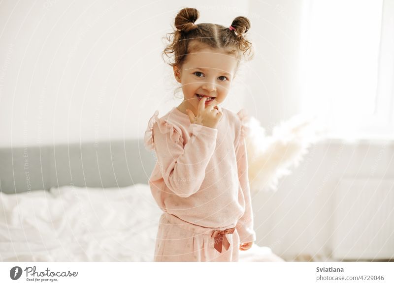 Porträt eines glücklichen Mädchens auf dem Bett im Schlafzimmer am Morgen nach dem Aufwachen Baby Stehen Raum Blick hell Kind niedlich heimwärts klein Kindheit
