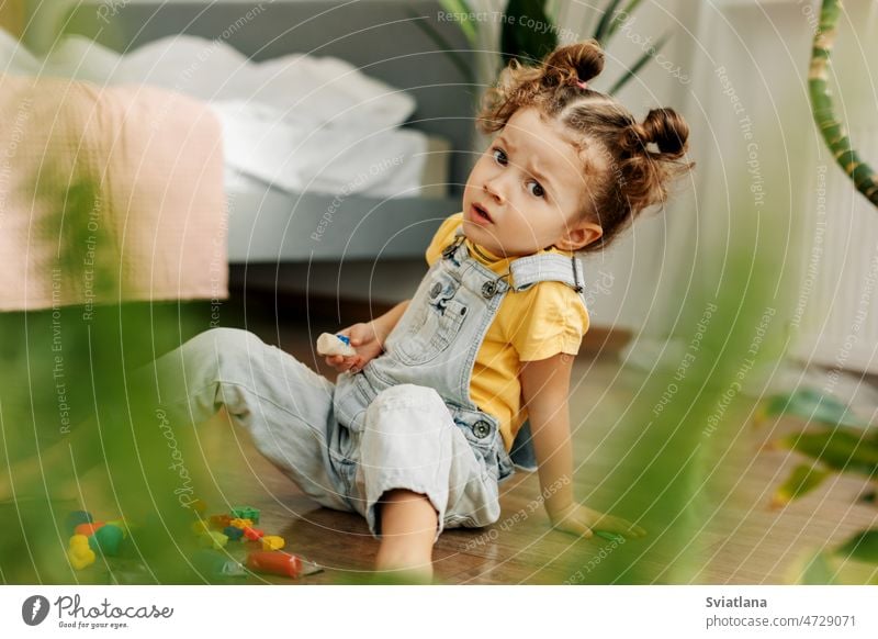 Das Porträt des Babys wird aus farbiger Knete auf dem Boden modelliert. Hausunterricht, kreative Freizeitgestaltung mit Kindern Mädchen spielen heimwärts
