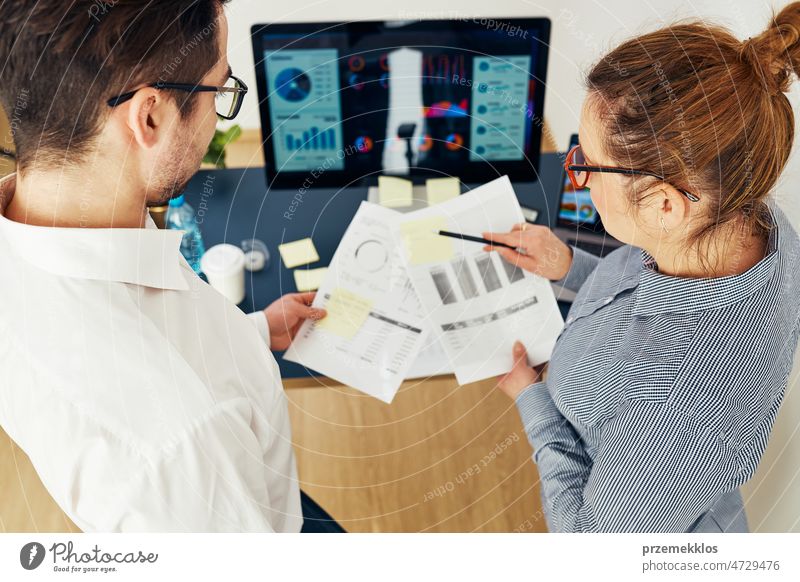 Geschäftskollegen besprechen Finanzdaten und arbeiten zusammen im Büro. Unternehmer arbeiten mit Diagrammen und Tabellen am Computer. Zwei Menschen arbeiten zusammen