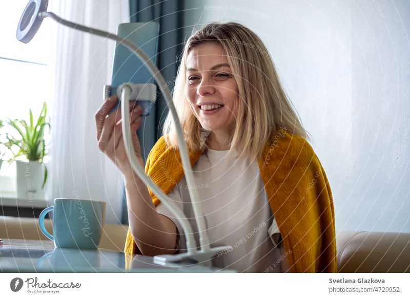 Blonde Frau macht Foto- oder Videoinhalte für soziale Medien mit Smartphone Authentisches Lifestyle-Porträt einer Person, die zu Hause arbeitet Aufzeichnen