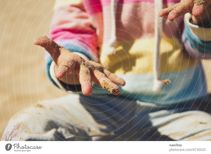 Nahaufnahme eines kleinen Mädchens, das am Strand mit dem Sand spielt Hände Baby Kindheit Neugier Regenbogen lernen erste Bokeh Zeit Familie Säuglingsalter