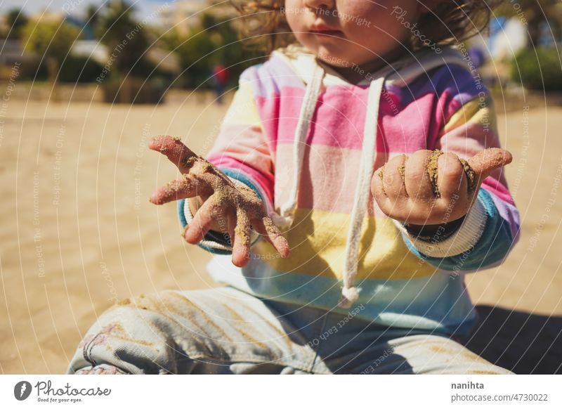 Nahaufnahme eines kleinen Mädchens, das am Strand mit dem Sand spielt Hände Baby Kindheit Neugier Regenbogen lernen erste Bokeh Zeit Familie Säuglingsalter