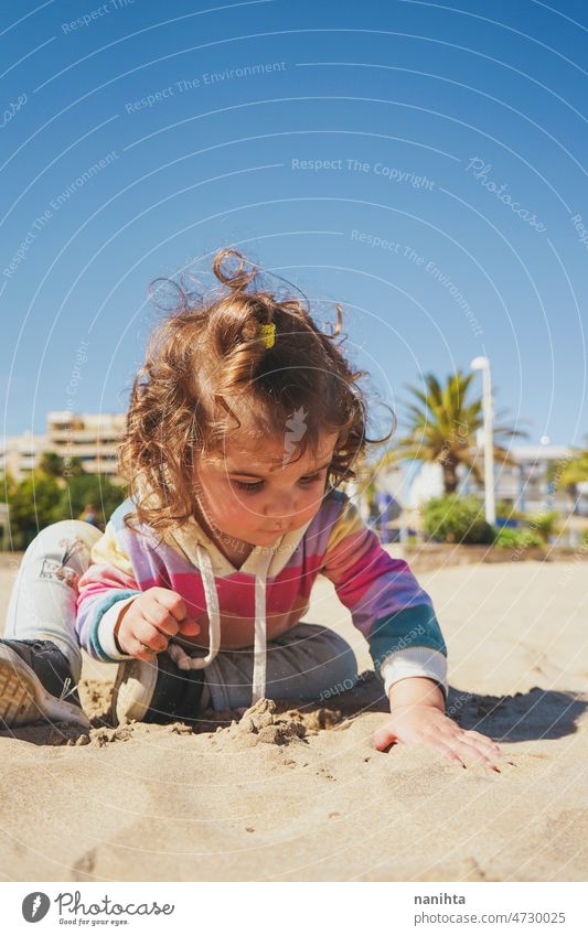 Kleinkind spielt mit dem Sand am Strand allein genießen Sommer erkunden Kindererziehung Freiheit Freude Glück Regenbogen Fröhlichkeit Szene lockig Behaarung