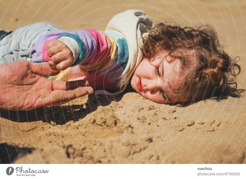 Kleines Mädchen spielt mit ihrem Vater im Sand Strand Familie Freude spielen spielerisch Glück Fröhlichkeit Kleinkind Papa Single Übung teilen Pflege