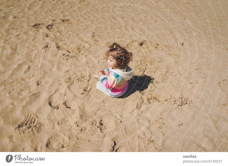 Kleinkind spielt mit dem Sand am Strand allein genießen Sommer erkunden Kindererziehung Freiheit Freude Glück Regenbogen Fröhlichkeit Szene lockig Behaarung
